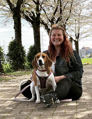 Jocelyn Birkes and her dog, Lilly, sitting under the cherry blossom trees at Spencer Smith Park in Burlington.
